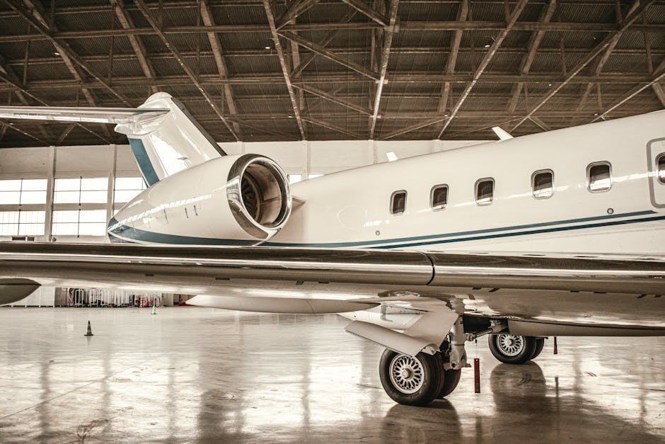 Private jet with visible engine inside spacious hangar