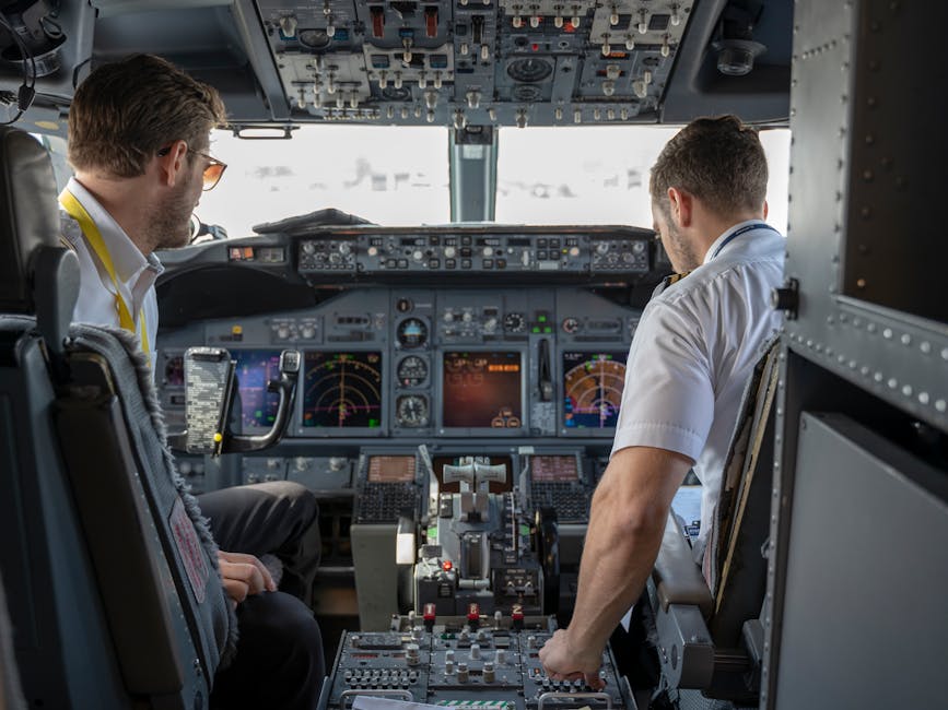 Two pilots navigating aircraft cockpit with advanced avionics