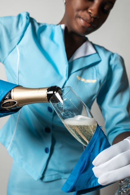 Flight attendant pouring champagne